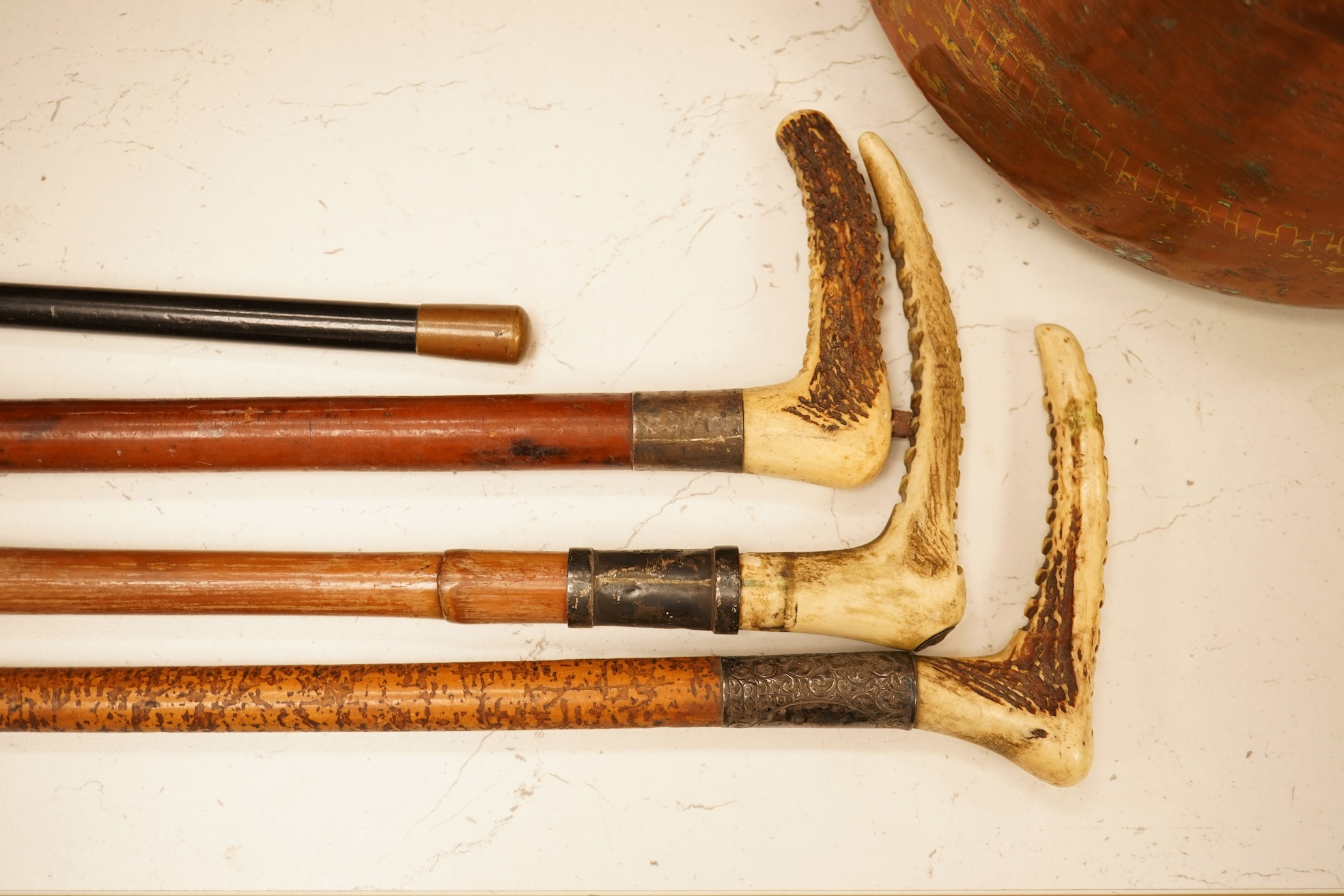 Three early 20th century antler handles riding crops with silver mounts and a swagger stick engraved Louise Martin, 1919